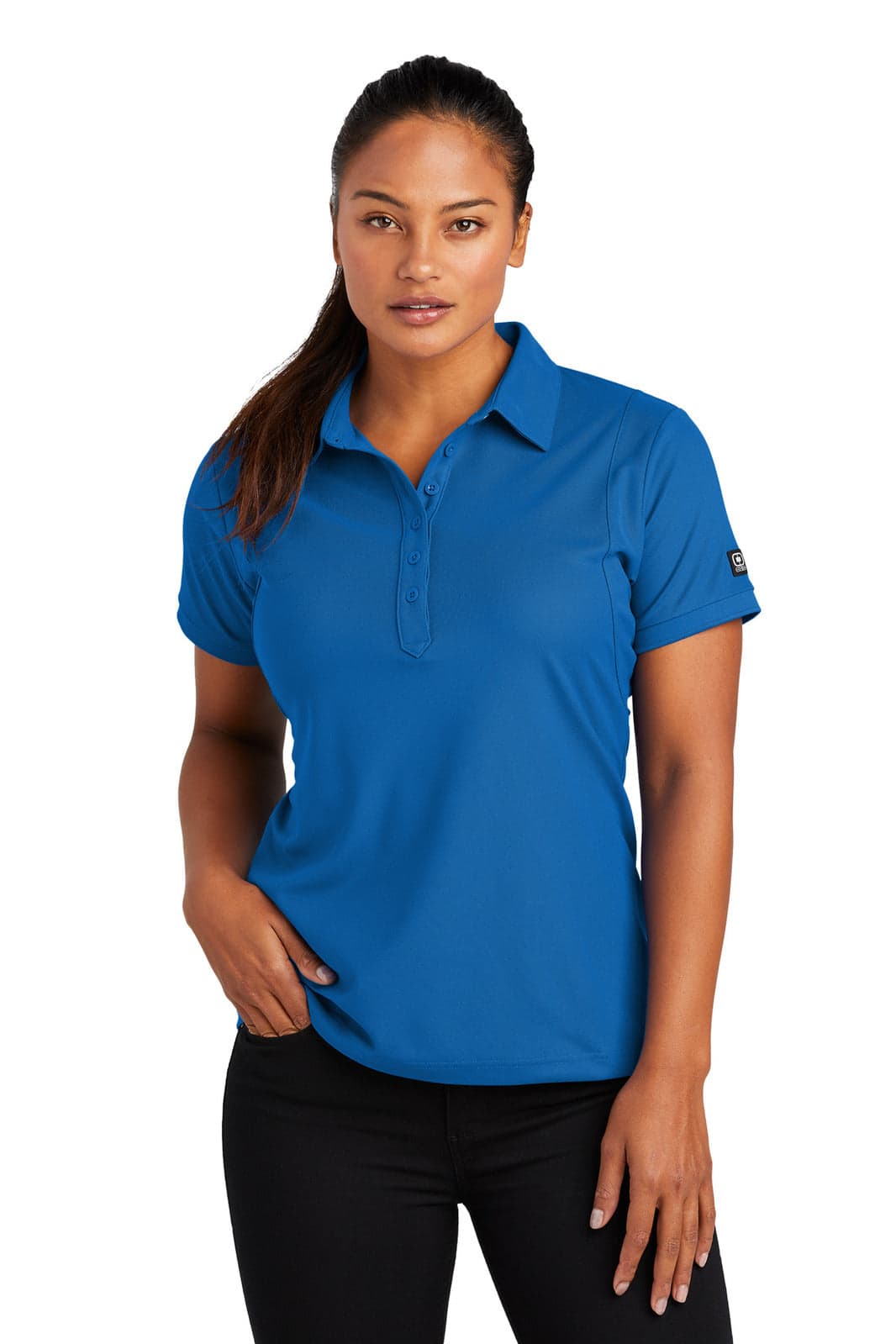 A woman is wearing a vibrant blue polo shirt with short sleeves, featuring a logo on the sleeve.
