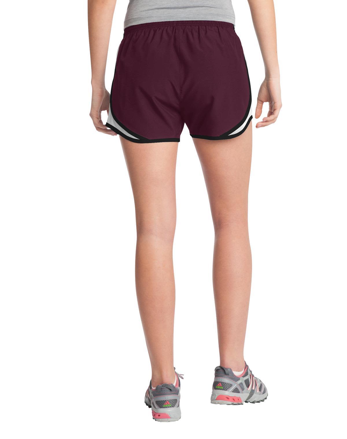 A pair of maroon sports shorts with black accents, featuring a logo, viewed from the back.