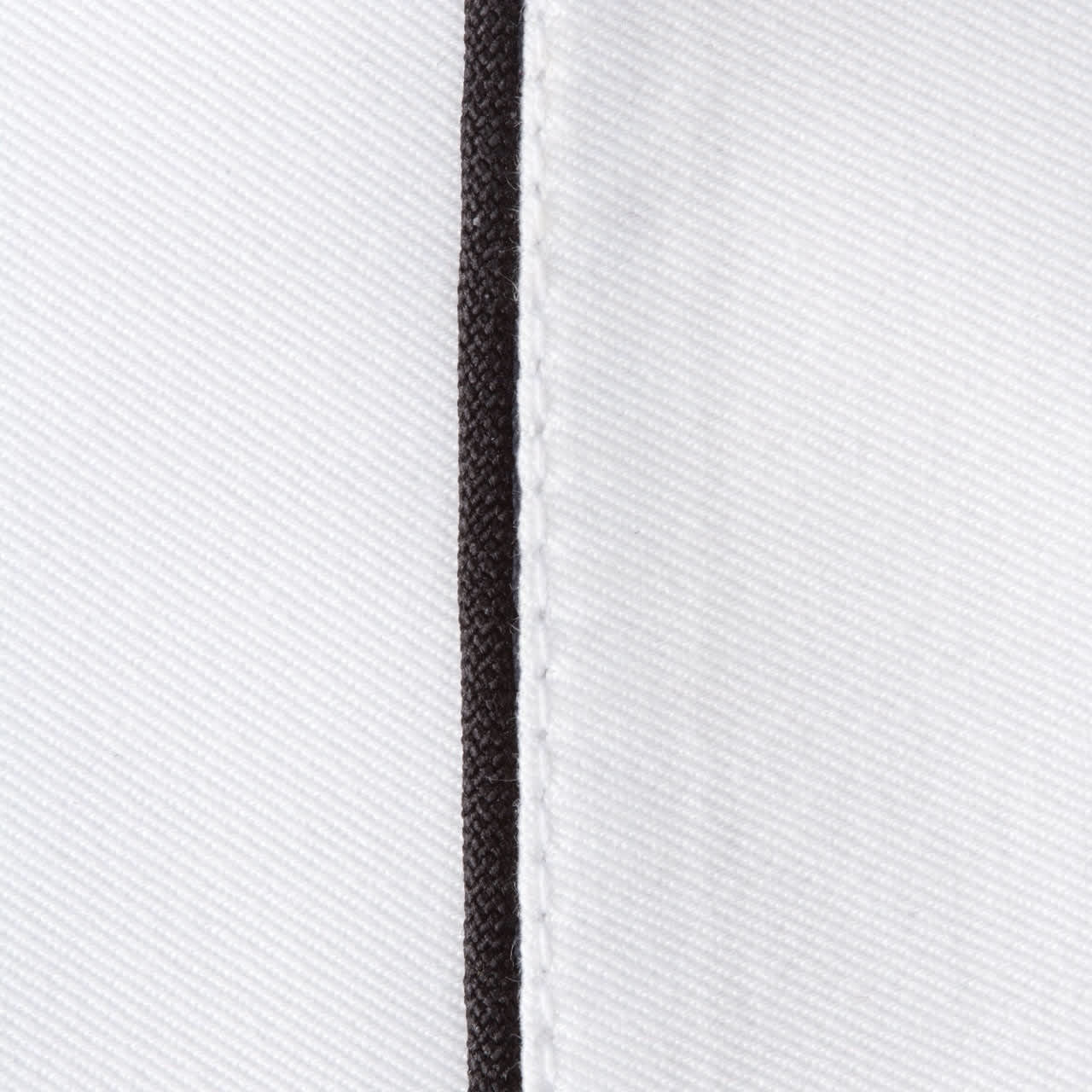 A close-up of a white chef jacket featuring black piping along the seams, with visible stitching details.