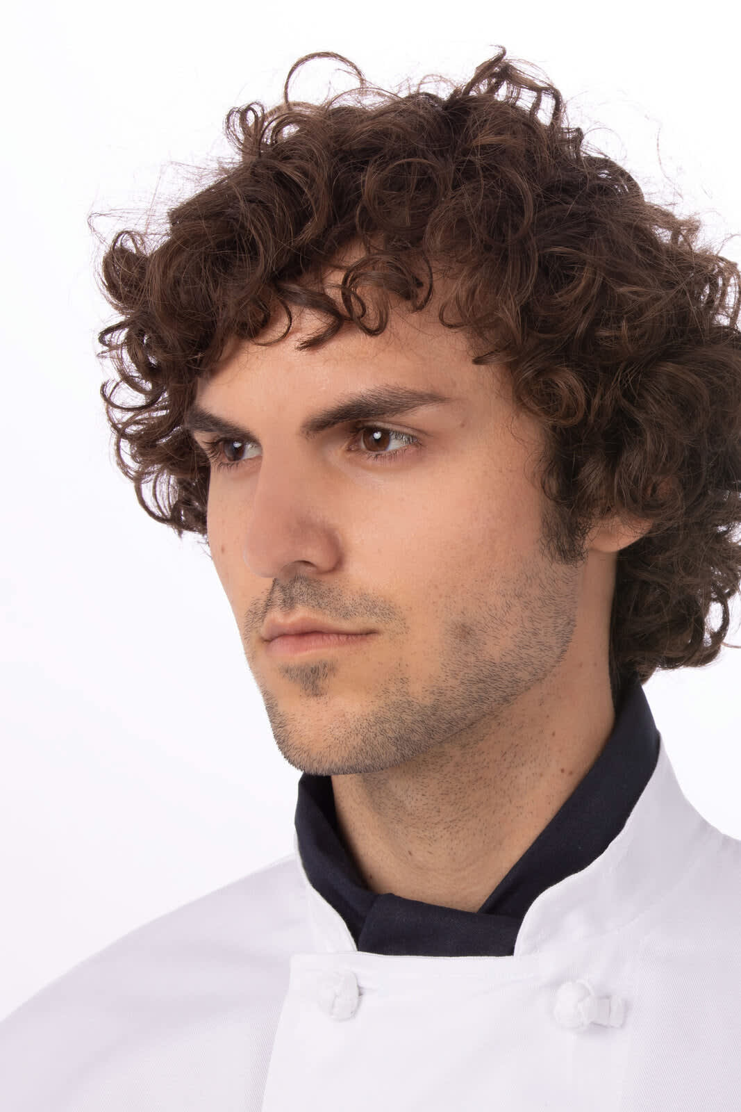 A chef neckerchief in navy blue, worn by a model with curly hair, dressed in a white chef jacket.