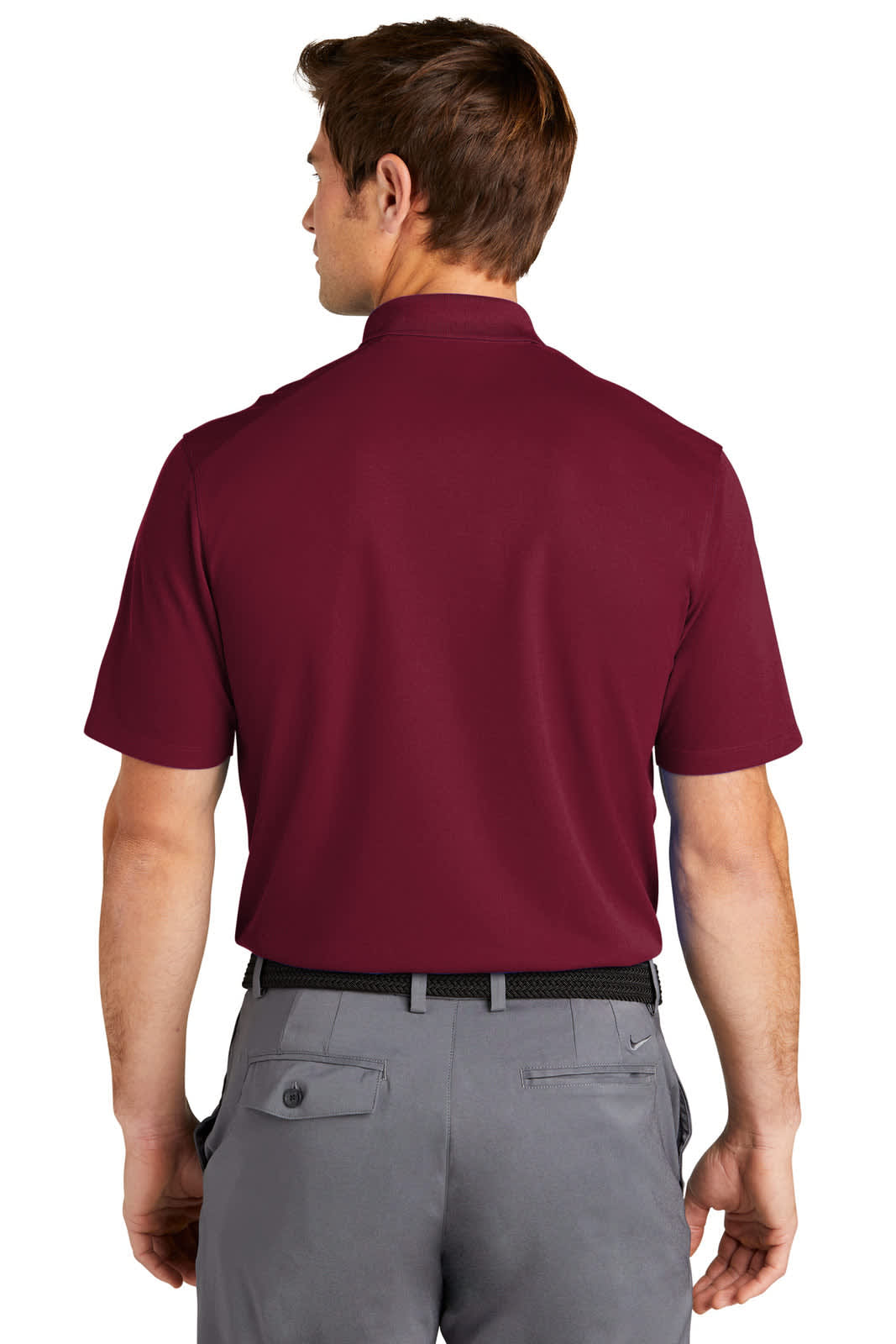 A man wearing a burgundy Nike Dri-FIT Micro Pique 2.0 Polo shirt from the back, paired with grey trousers.