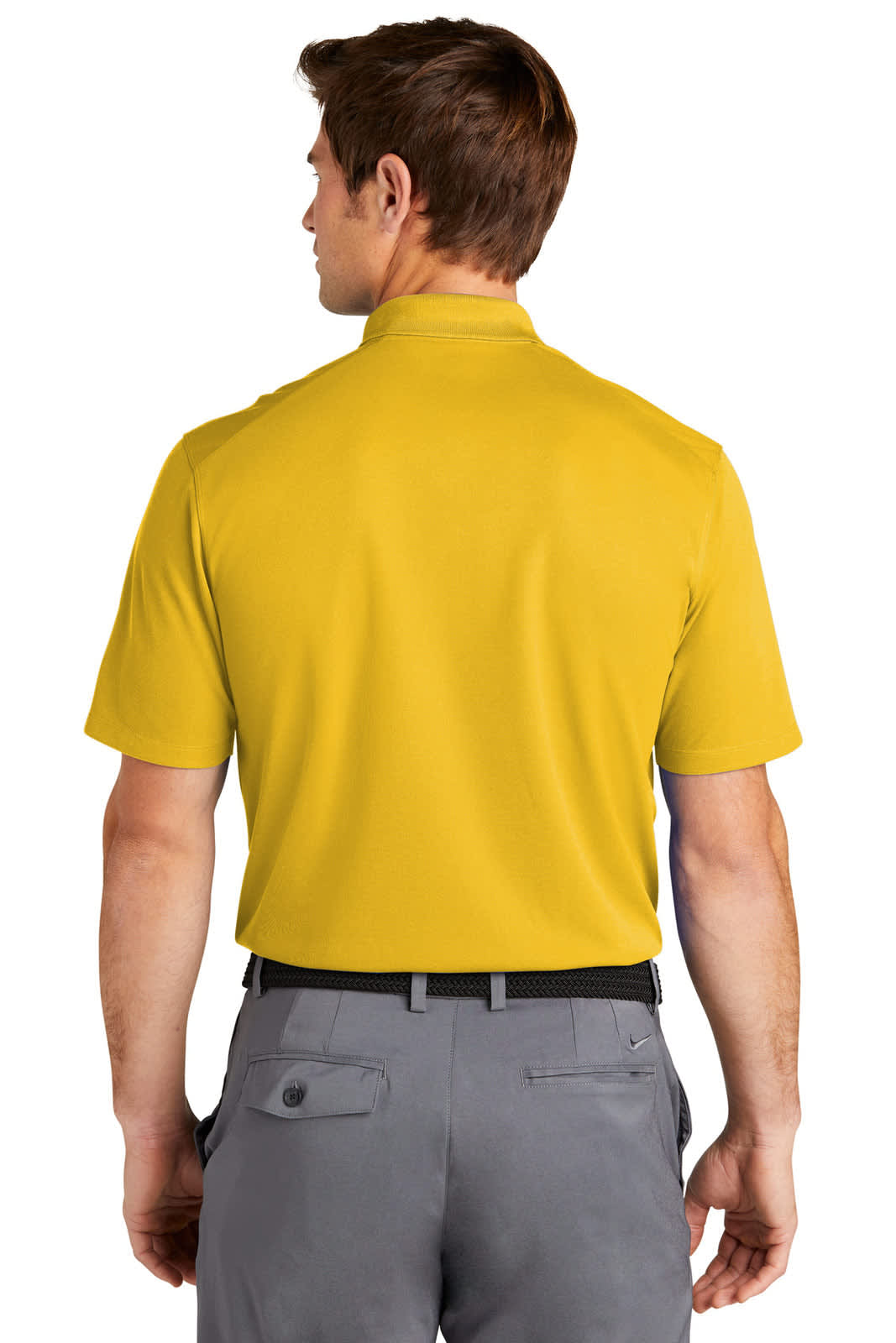 A man is wearing a yellow polo shirt, viewed from the back, paired with grey trousers. The shirt features a logo.