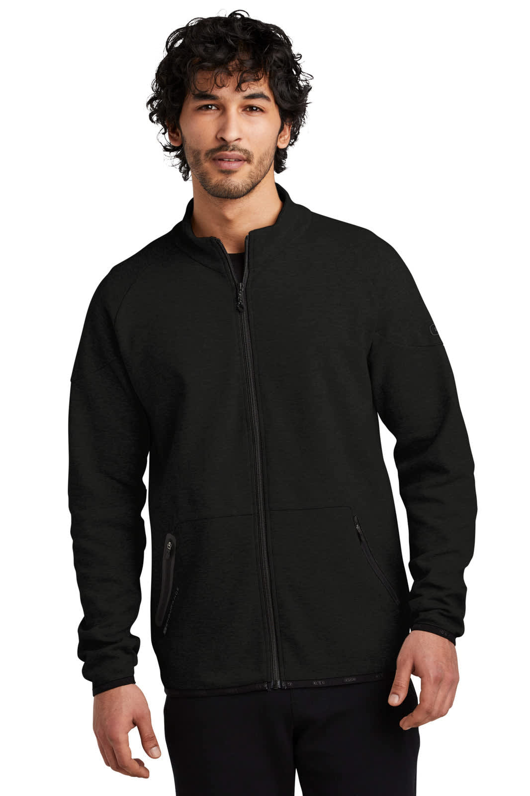 A black OGIO ENDURANCE Origin Jacket with a zip closure and side pockets, featuring a logo.