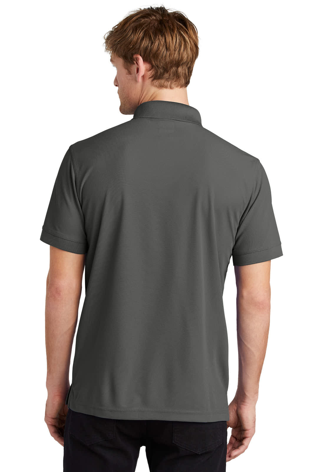 A person wearing a charcoal grey OGIO Caliber 2.0 polo shirt, viewed from the back. The shirt features a collar and short sleeves.