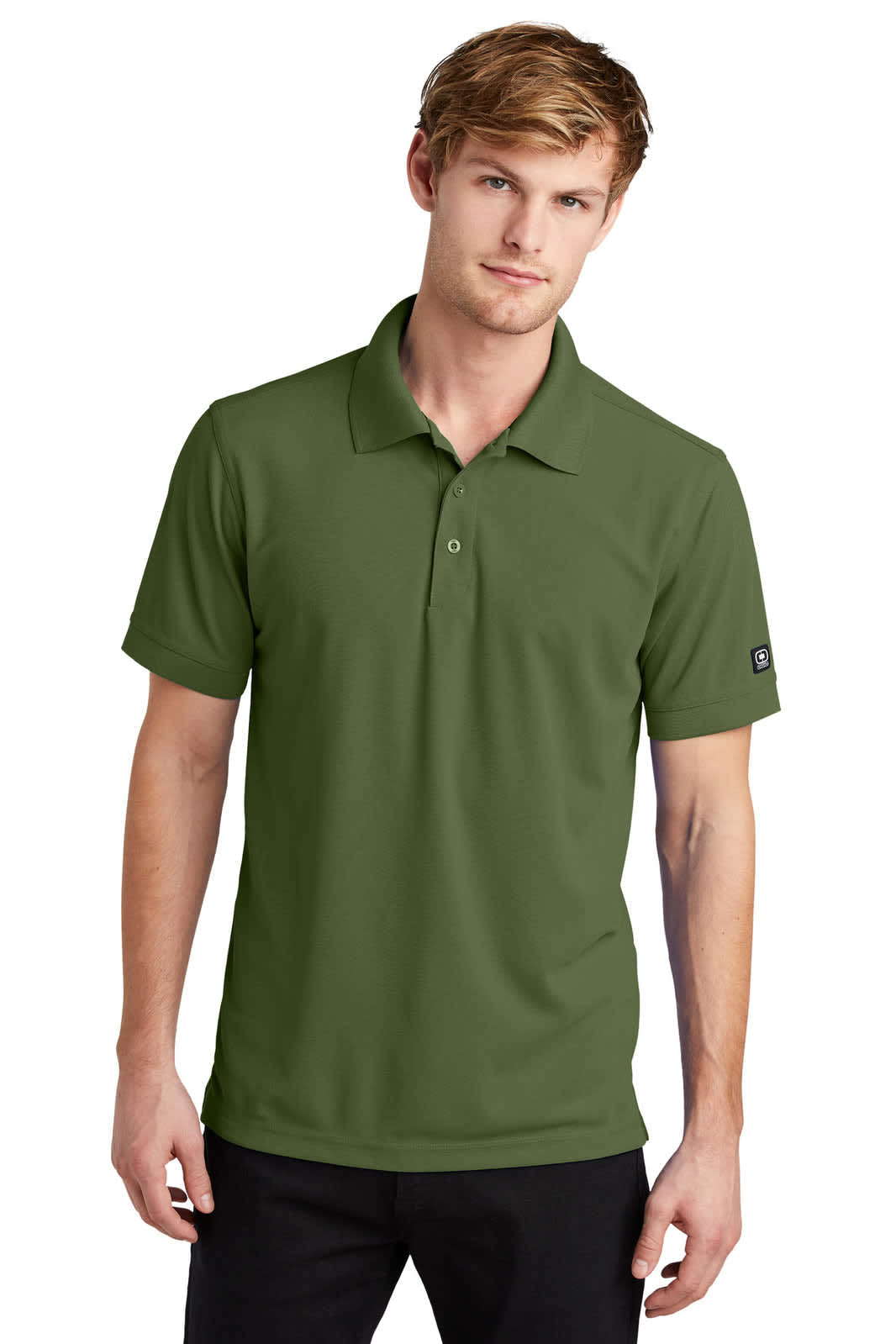 A green polo shirt worn by a model, featuring a collar and short sleeves, with a logo on the sleeve.