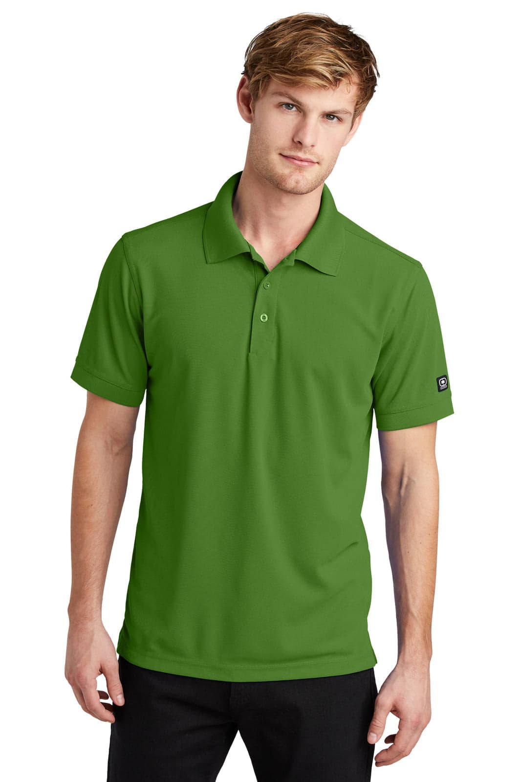 A green polo shirt is worn by a male model, featuring a collar and short sleeves, with a logo on the sleeve.