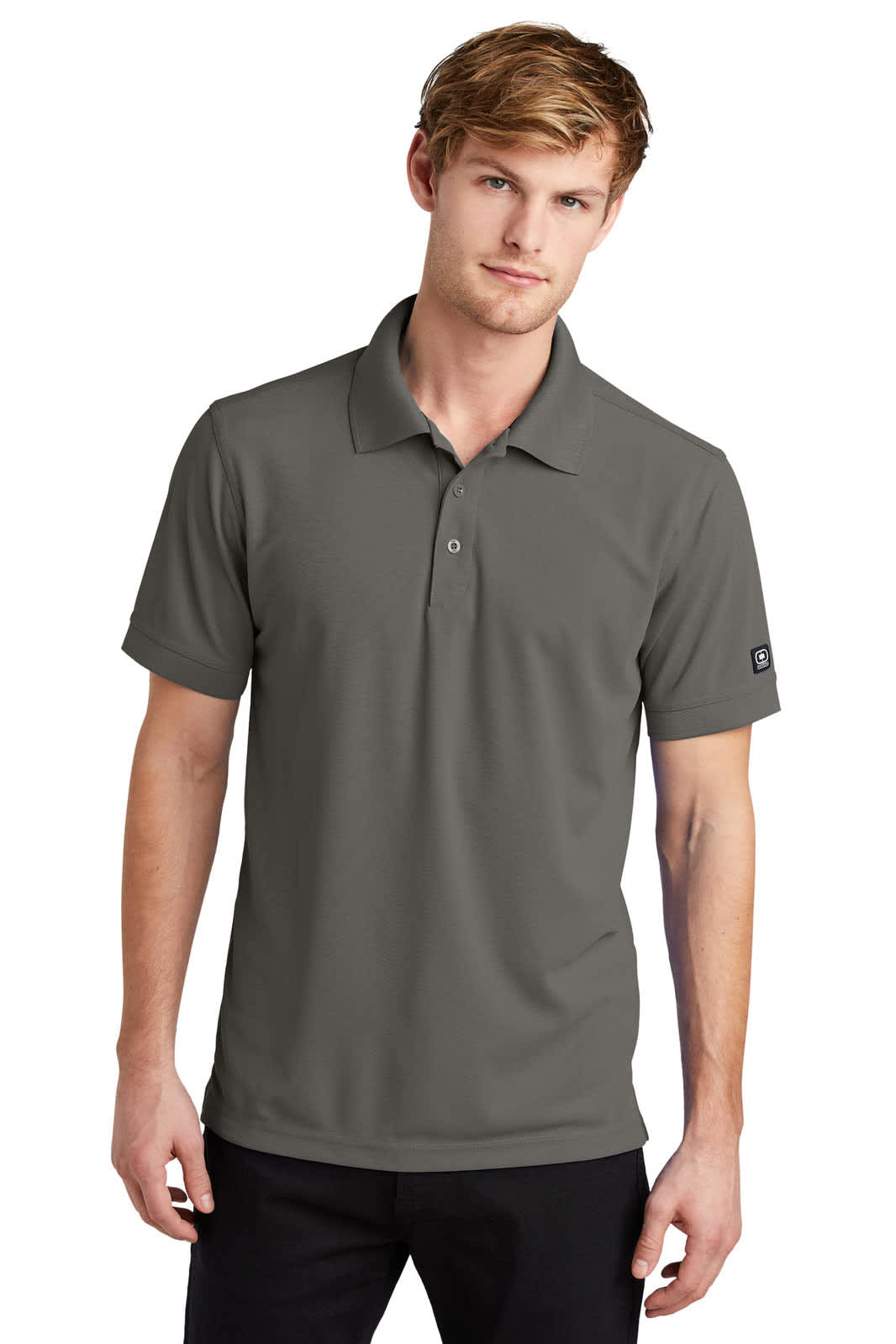 A grey polo shirt worn by a man, featuring a collar and short sleeves, with a logo on the sleeve.