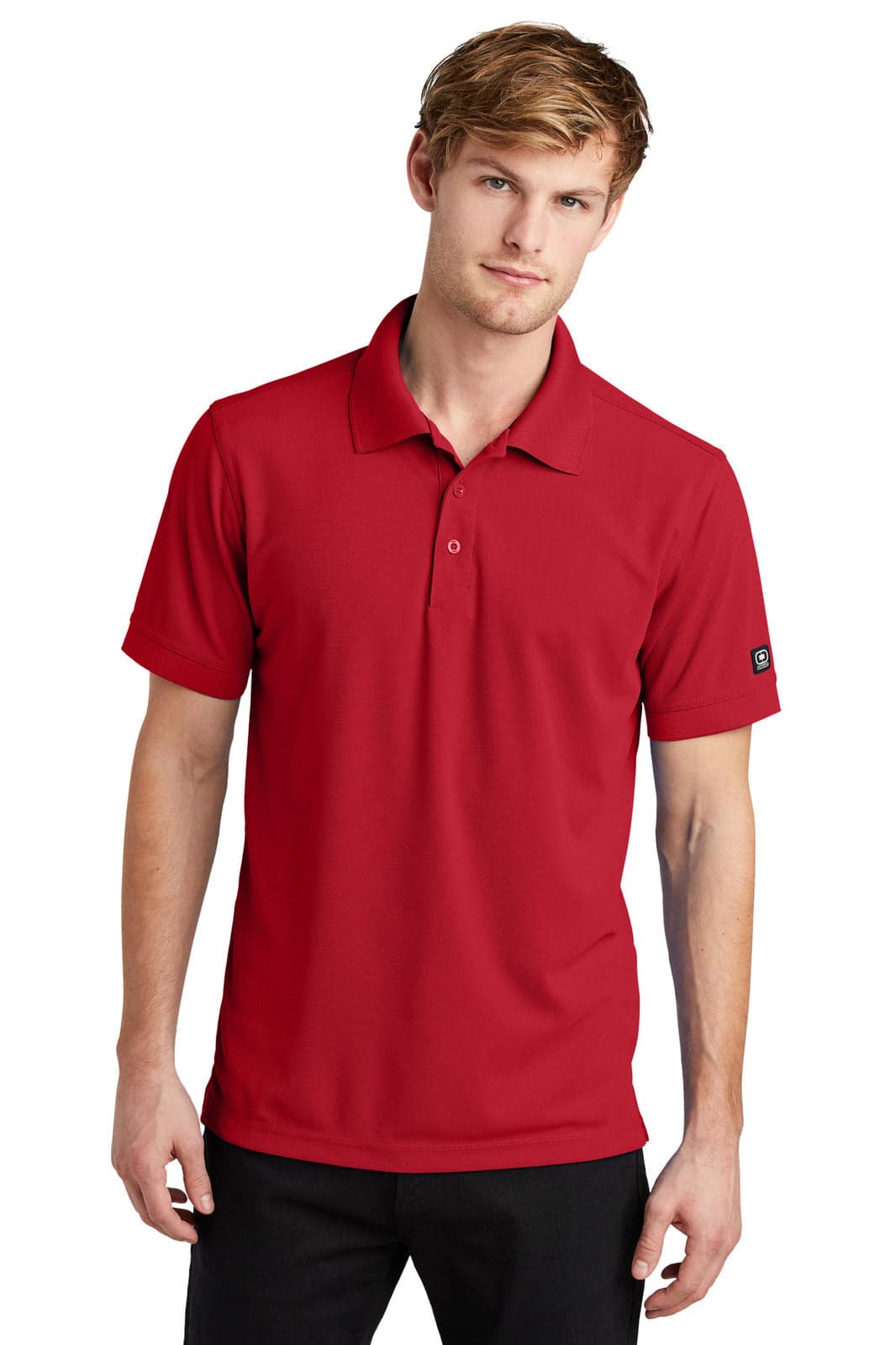 A red OGIO - Caliber2.0 polo shirt with a collar and short sleeves, featuring a logo on the sleeve.