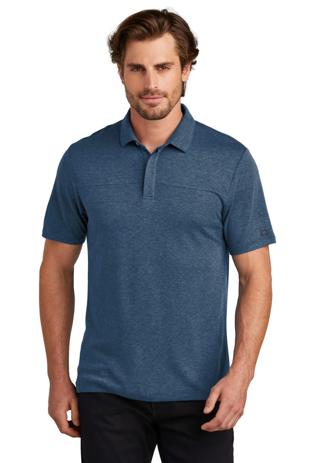 A man is wearing a blue OGIO Command Polo shirt, featuring a collar and short sleeves. The shirt has a logo.