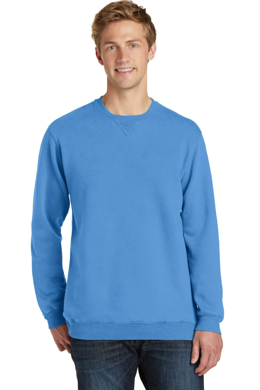A man wearing a blue pigment-dyed crewneck sweatshirt, styled with a casual fit. The sweatshirt features a logo.
