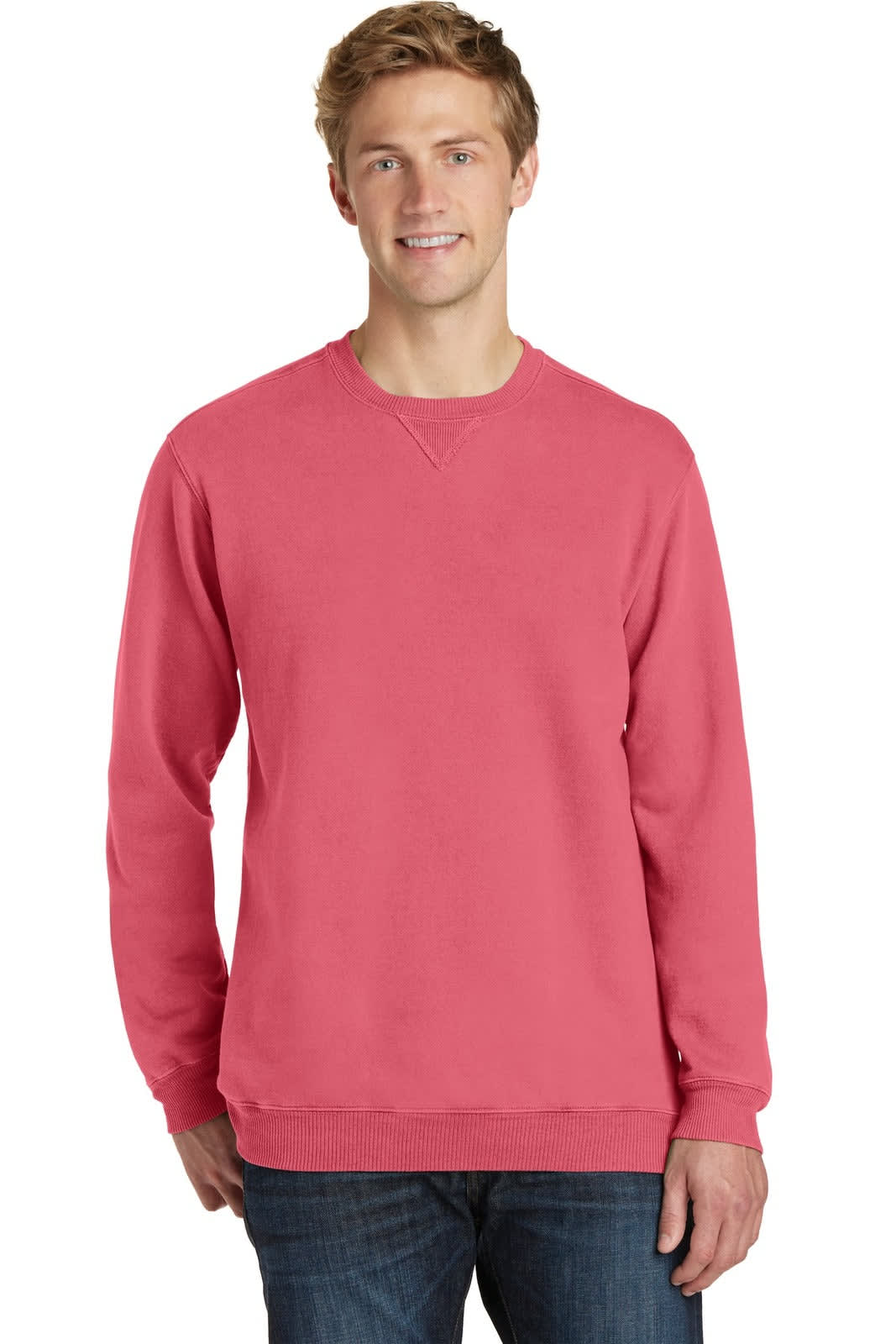 A crewneck sweatshirt in coral pink worn by a model, featuring long sleeves and a relaxed fit.