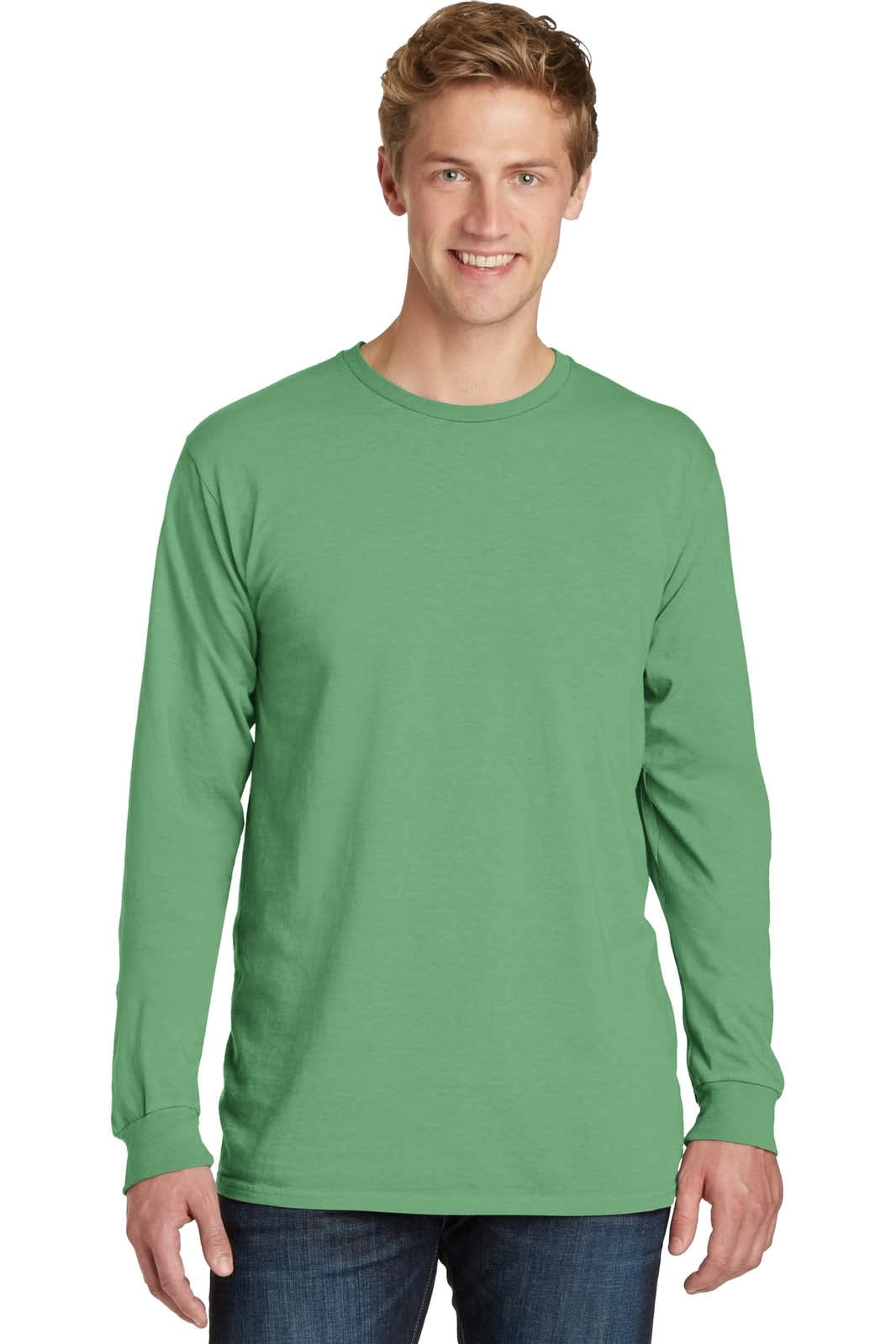 A green long sleeve tee worn by a model, featuring a logo on the front and styled with denim jeans.