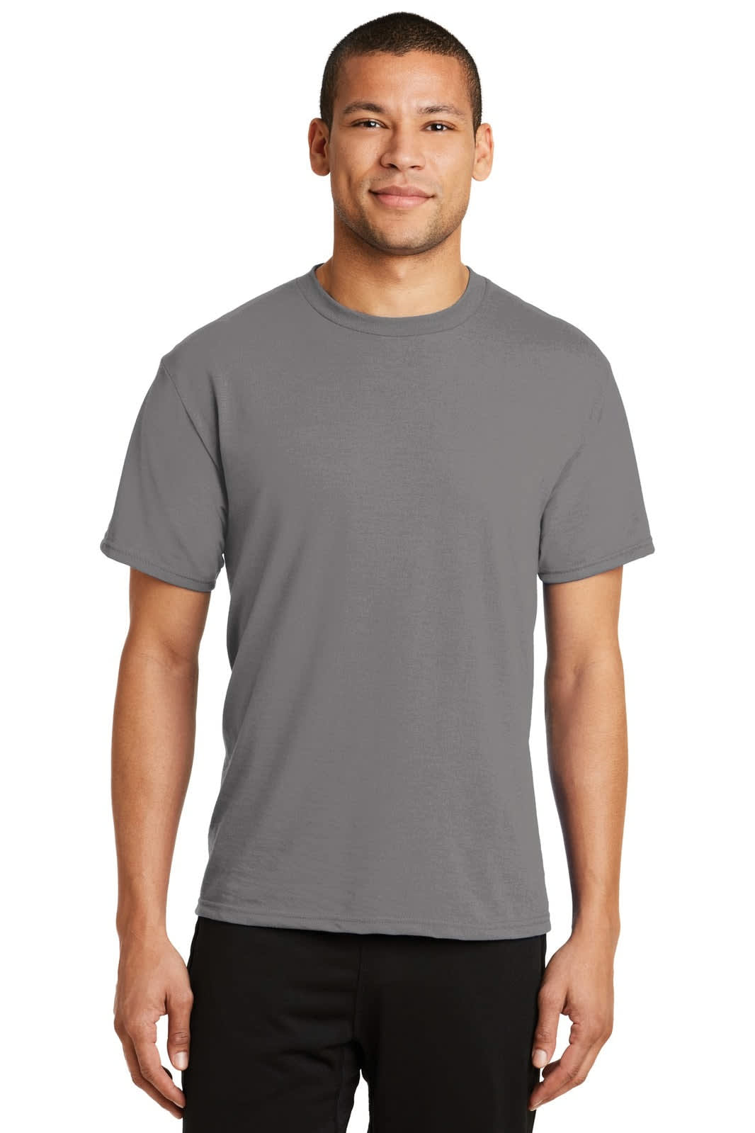 A man wearing a grey Port & Company Performance Blend T-Shirt, standing against a neutral background.