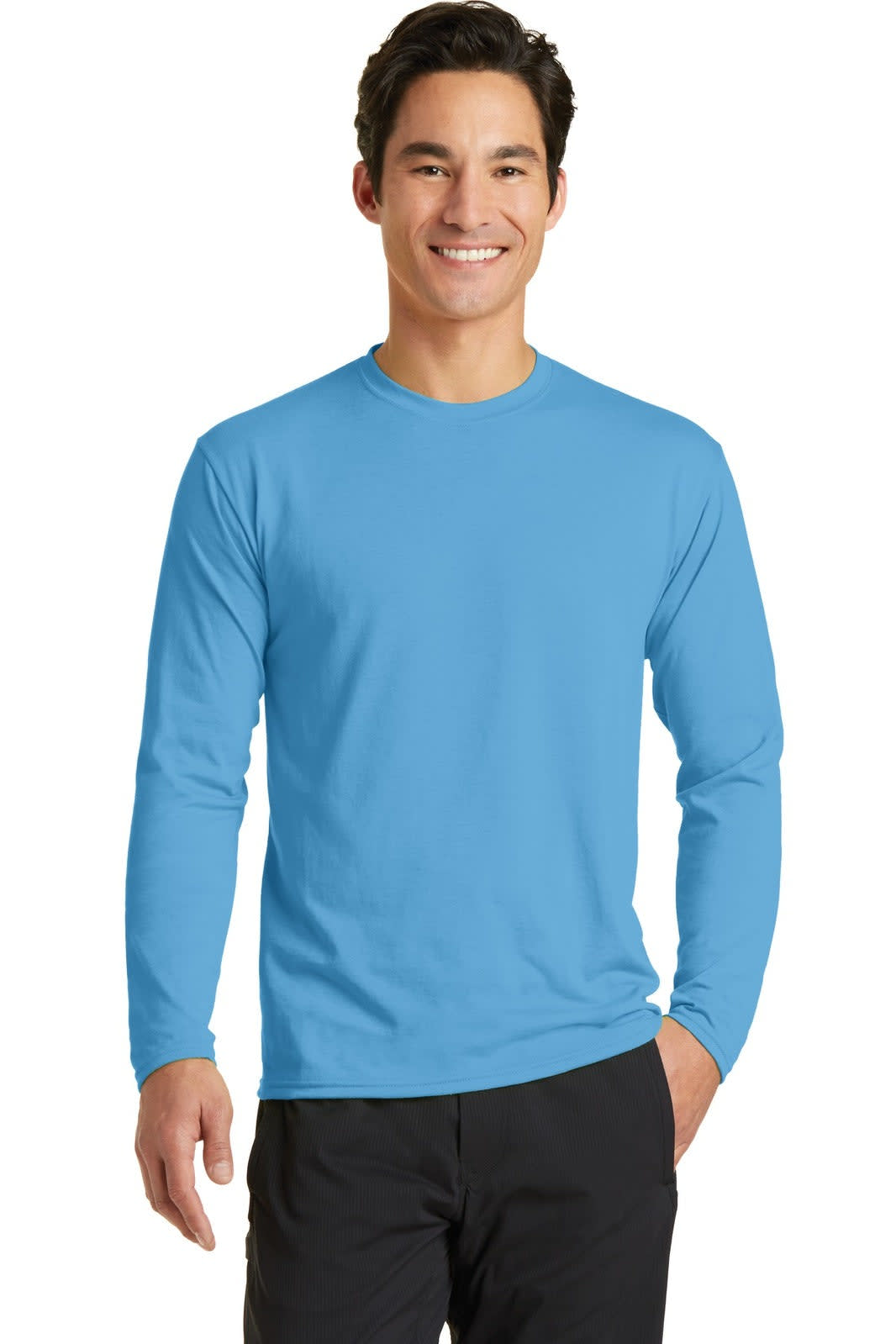 A man wearing a bright blue long sleeve performance blend tee, standing with a smile. The shirt features a logo.