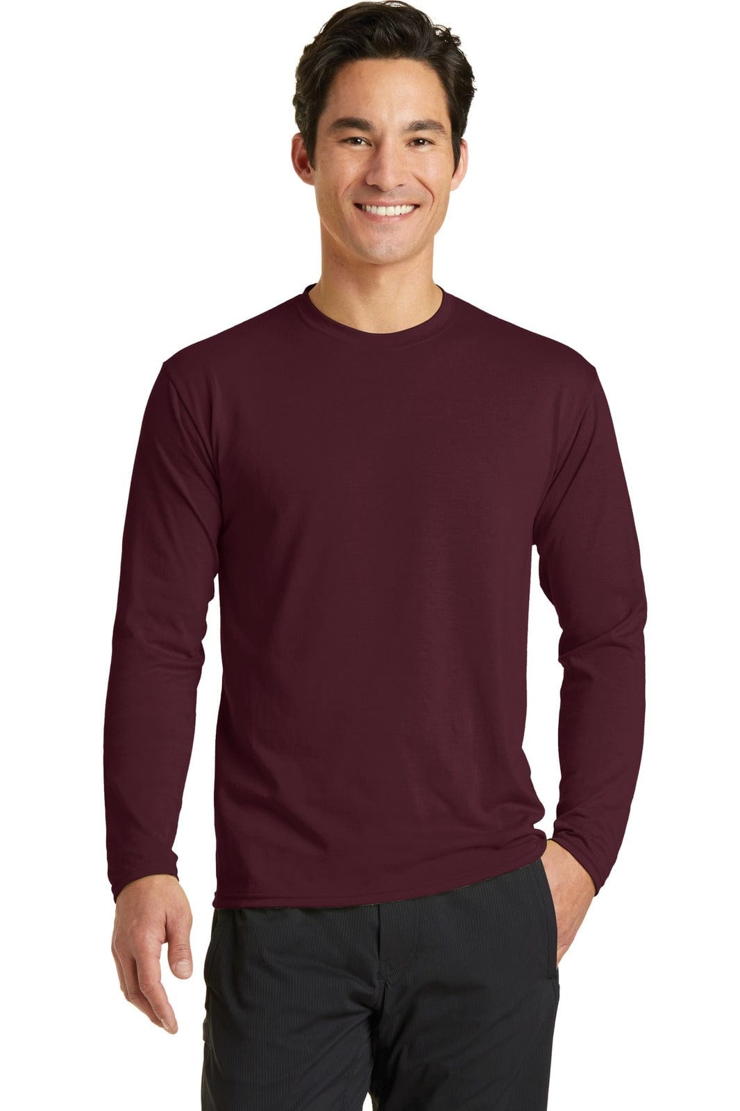 A long sleeve performance blend tee in maroon worn by a smiling male model, featuring branding.