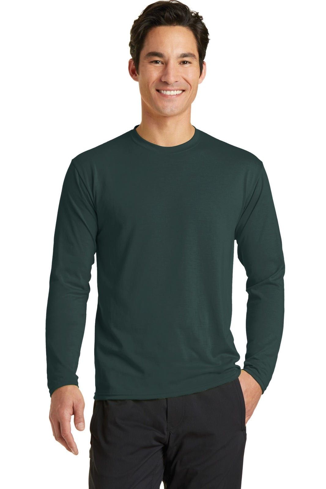 A long sleeve performance blend tee in dark green, featuring a logo, modelled by a smiling man.