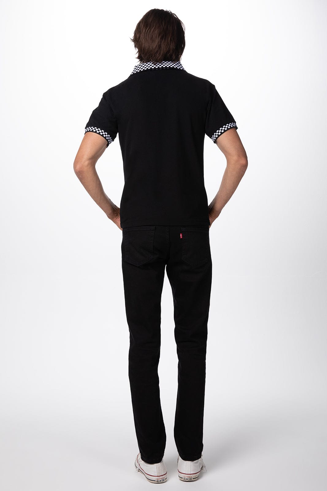 A black traditional men's polo shirt with patterned collar detail, displayed on a model seen from the back.