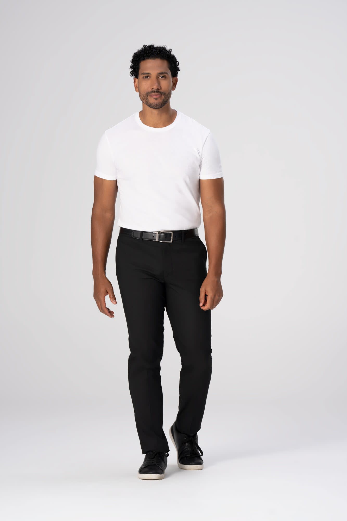 Chino men's poly stretch pants in black, paired with a white t-shirt, worn by a model standing against a light background.