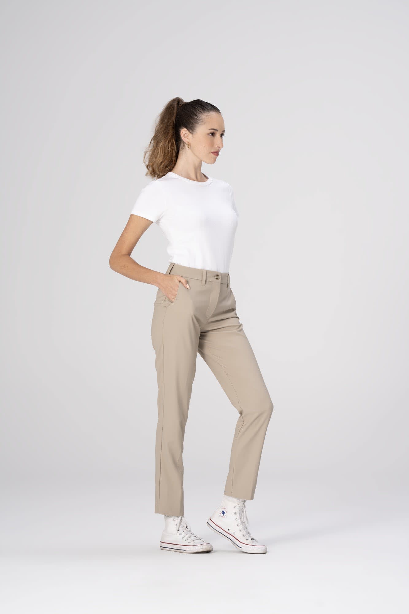 Chino Women's poly stretch pants in beige, styled with a white t-shirt and white sneakers, featuring side pockets.