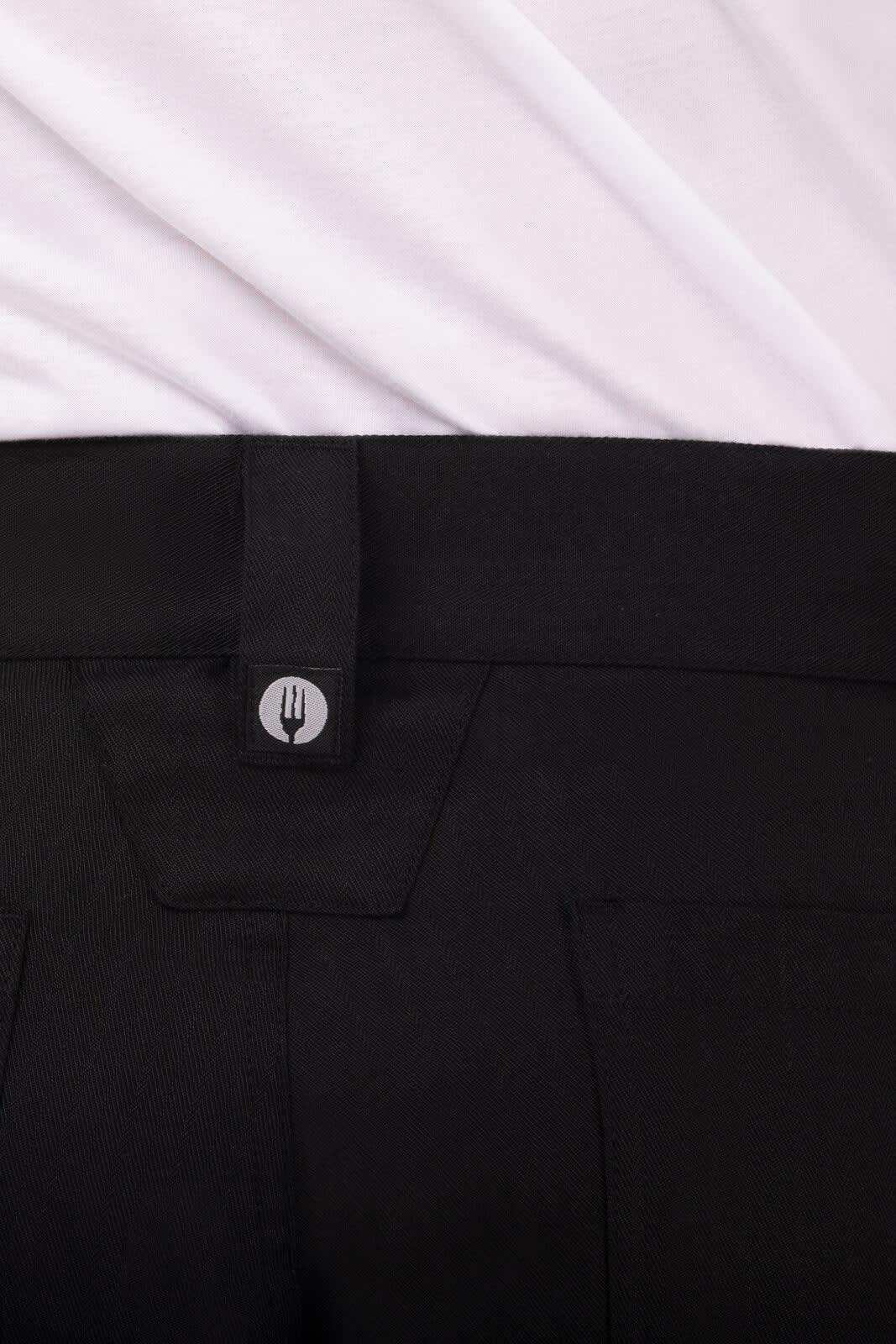 Black chef pants featuring a button closure and a logo on the waistband.