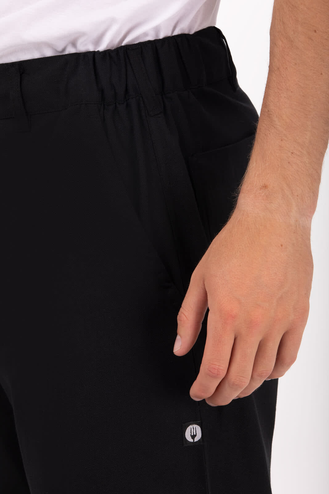 Black chef pants featuring an elastic waistband and a logo on the side. Ideal for professional kitchen use.