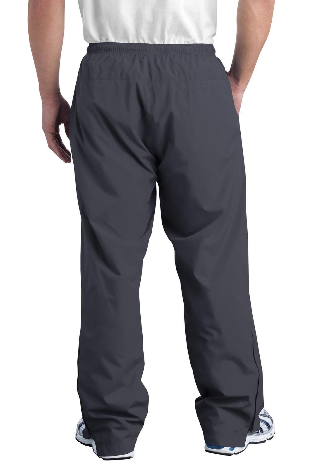 A pair of grey Sport-Tek Wind Pants with an elastic waistband and a loose fit, featuring a logo on the side.