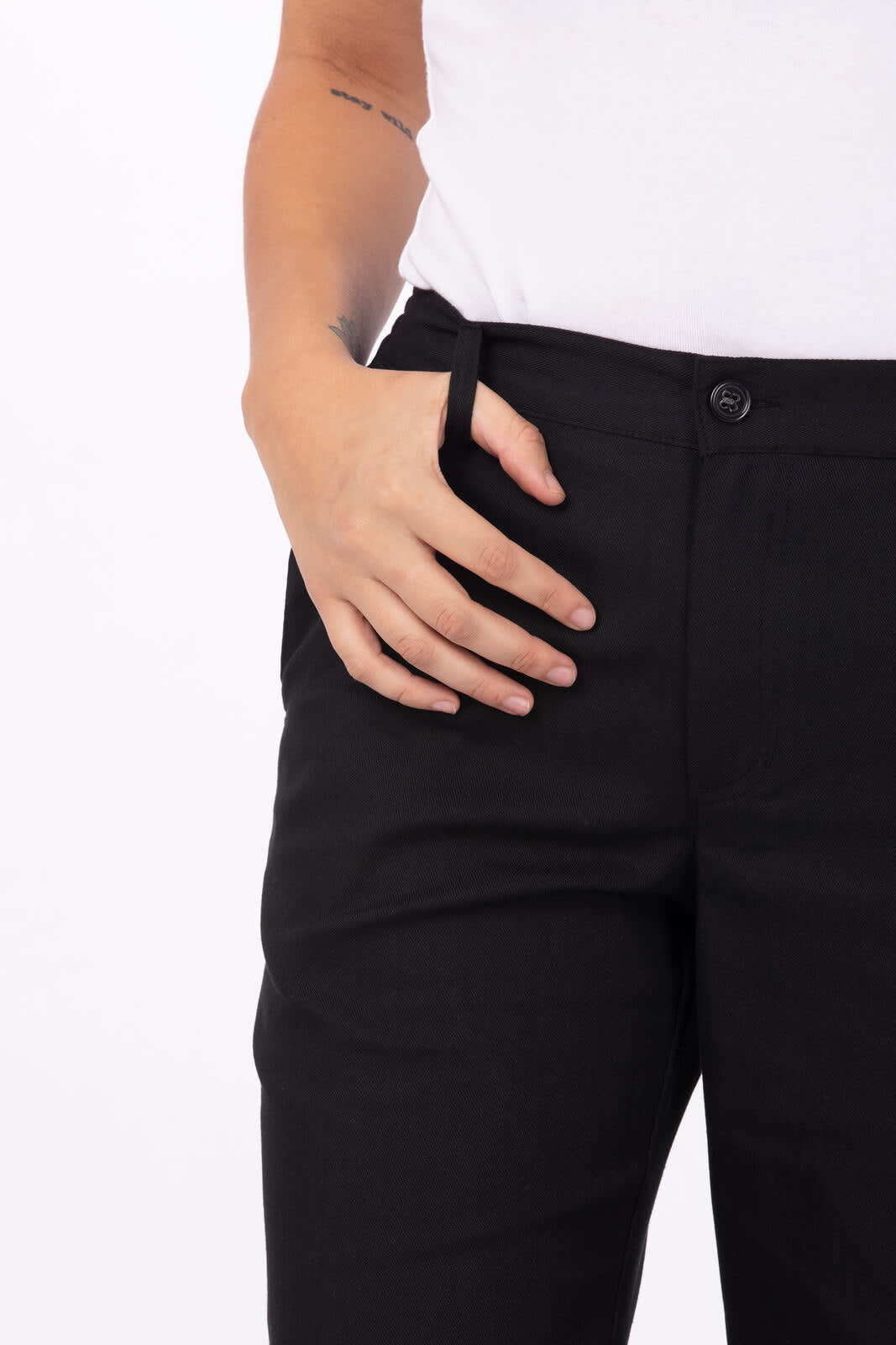 Black women's chef pants featuring a button closure and side pockets, with a model's hand resting on the hip.