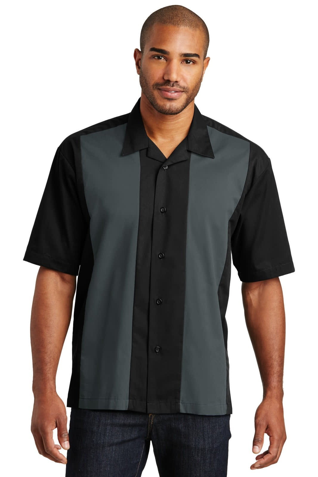 A man wearing a short-sleeve button-up shirt featuring a black and grey design, with a logo on the chest.
