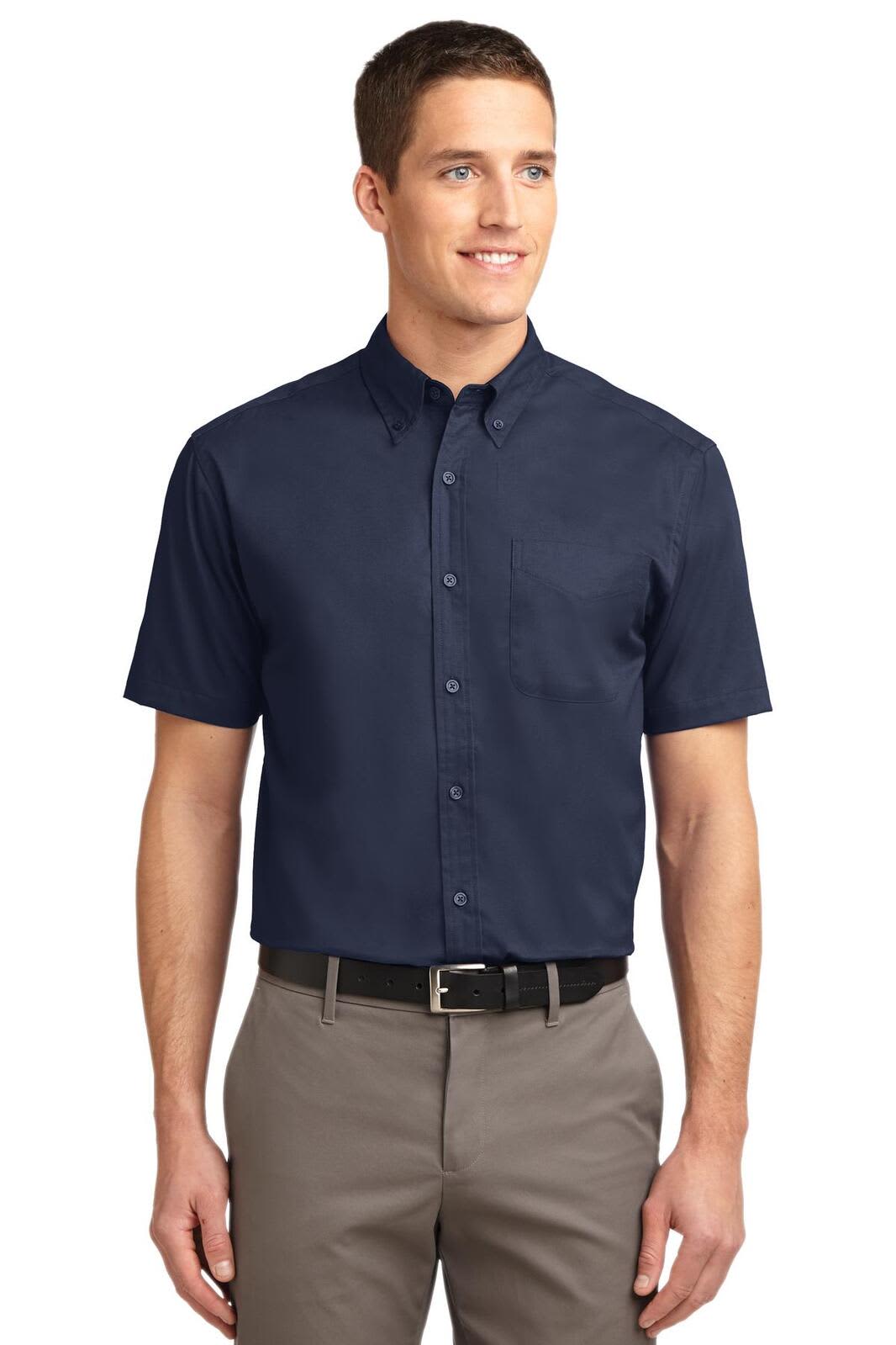 A short sleeve button-up shirt in navy blue with a collar and a logo on the chest. The model is wearing khaki trousers.