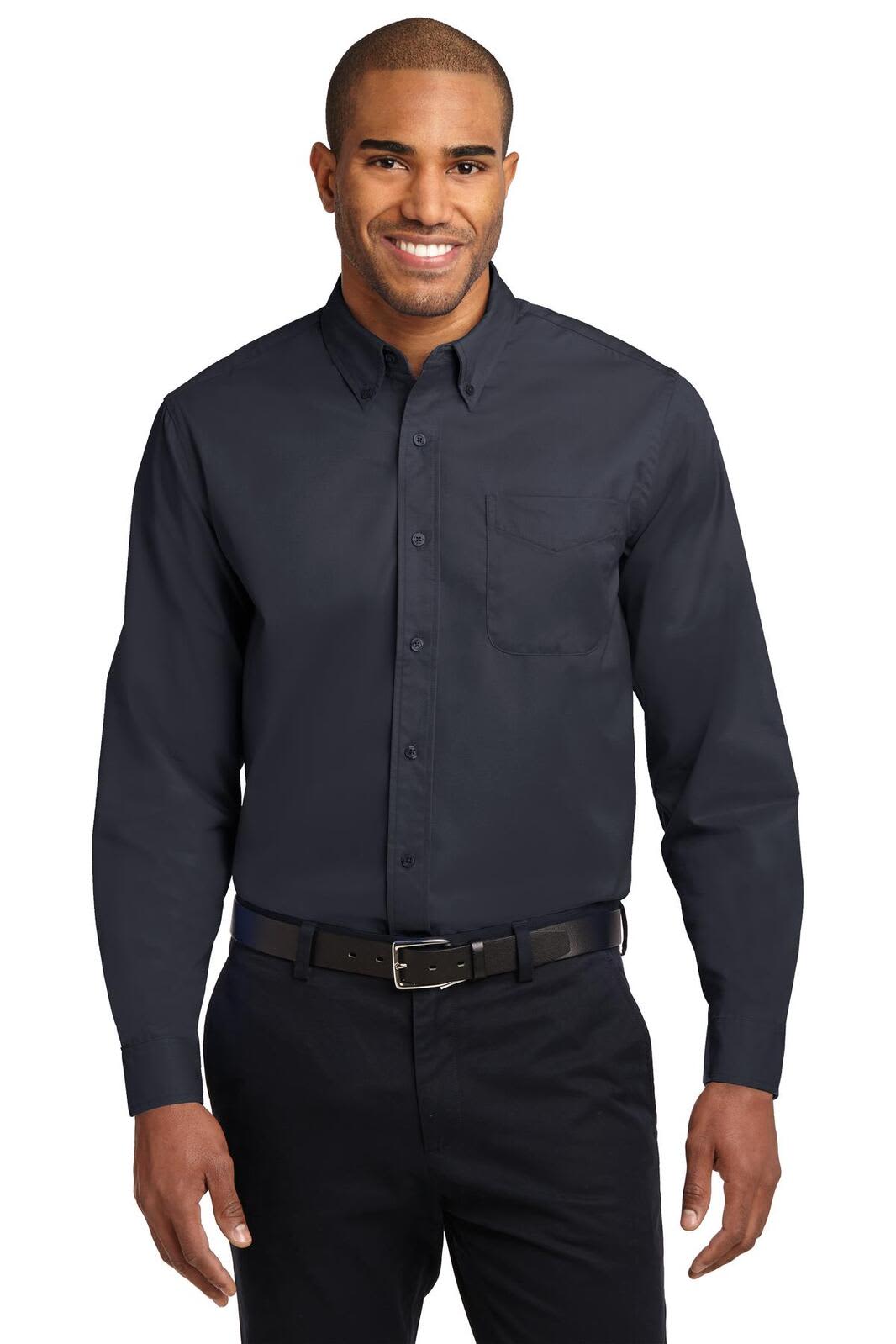 A man wearing a dark navy long sleeve button-up shirt with a pocket and a belt. The shirt features a logo.