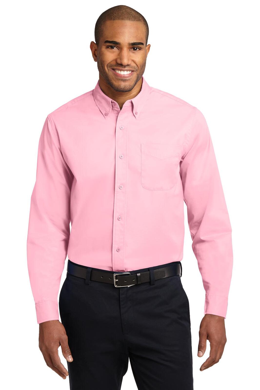 A long sleeve button-up shirt in pink, featuring a pocket and a logo, worn by a smiling man.
