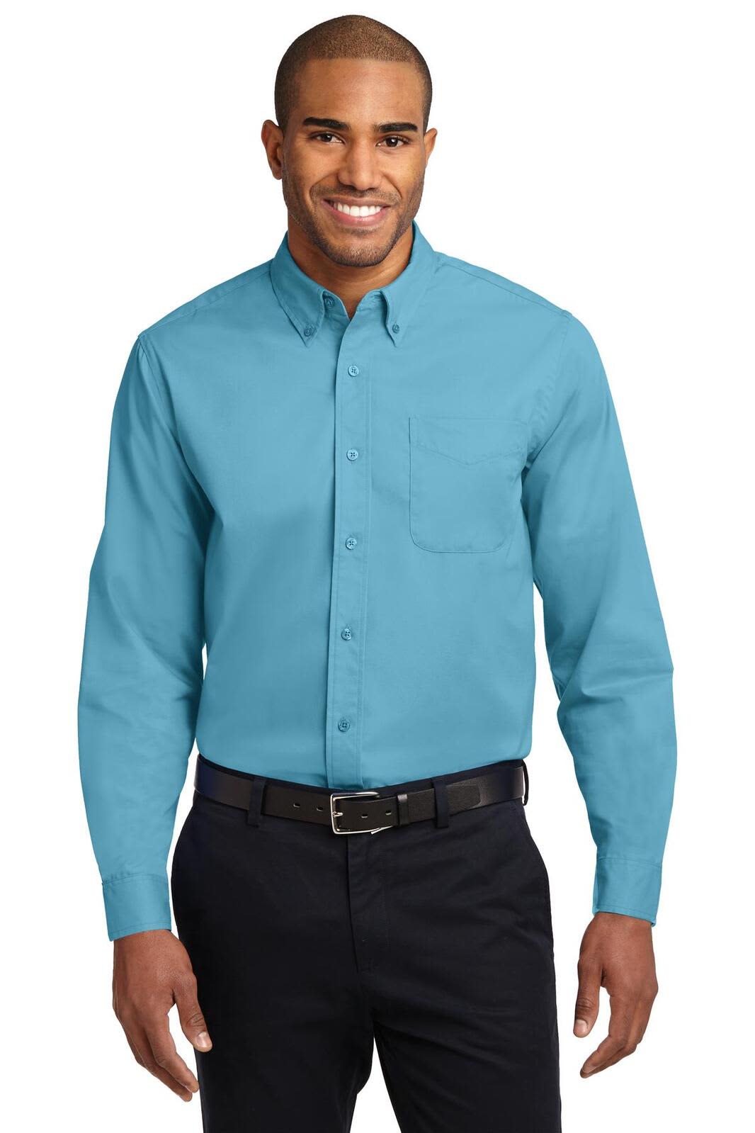 A man wearing a teal long sleeve button-up shirt with a chest pocket, paired with dark trousers and a belt.