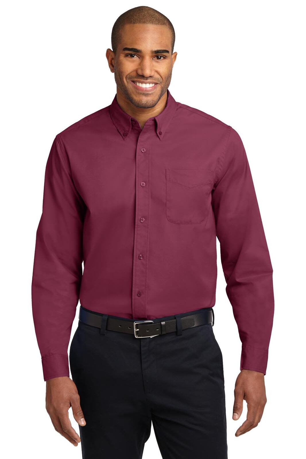 A man wearing a long sleeve, button-up shirt in burgundy, featuring a front pocket and a branded logo.