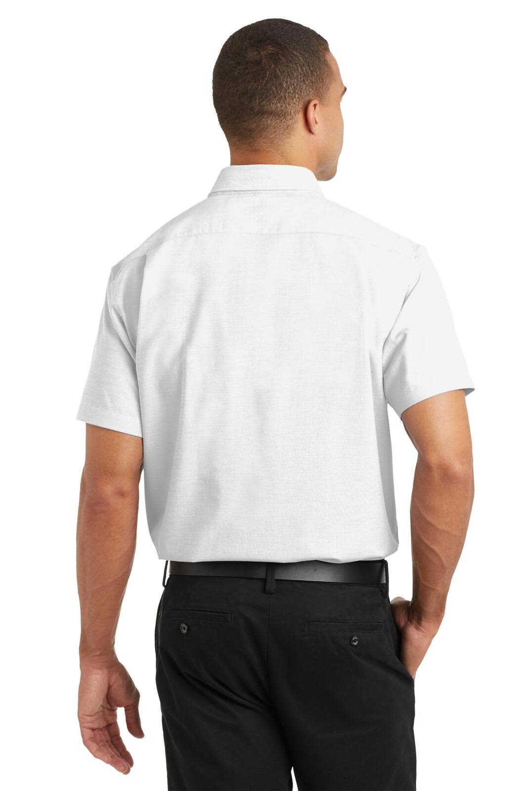 A man wears a short-sleeve, white Port Authority SuperPro Oxford shirt from the back, paired with dark trousers.
