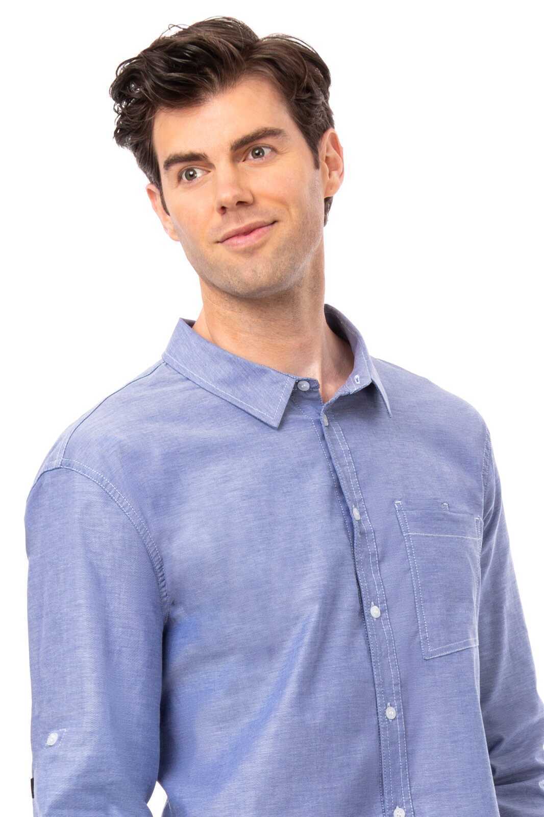 A blue button-up men's classic shirt with a chest pocket and a collar, featuring a logo.