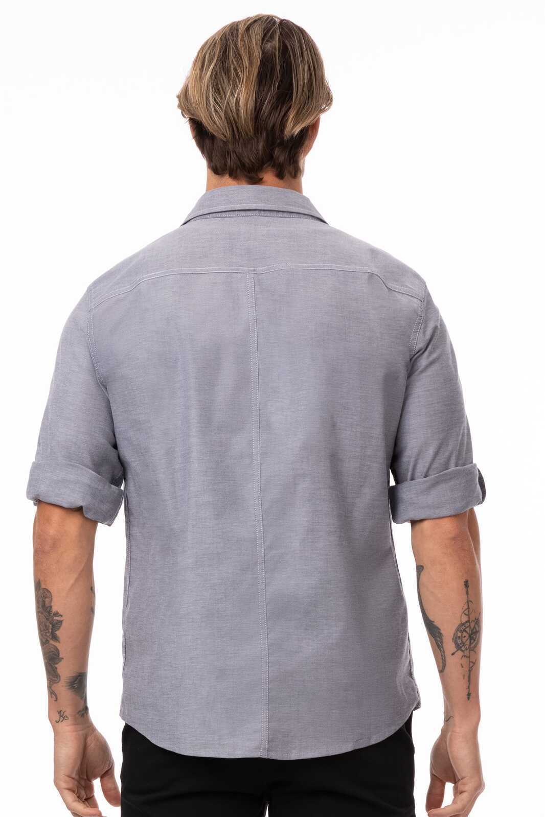 A blue, button-up, short-sleeved men's classic shirt with rolled cuffs and a subtle texture, featuring a logo.