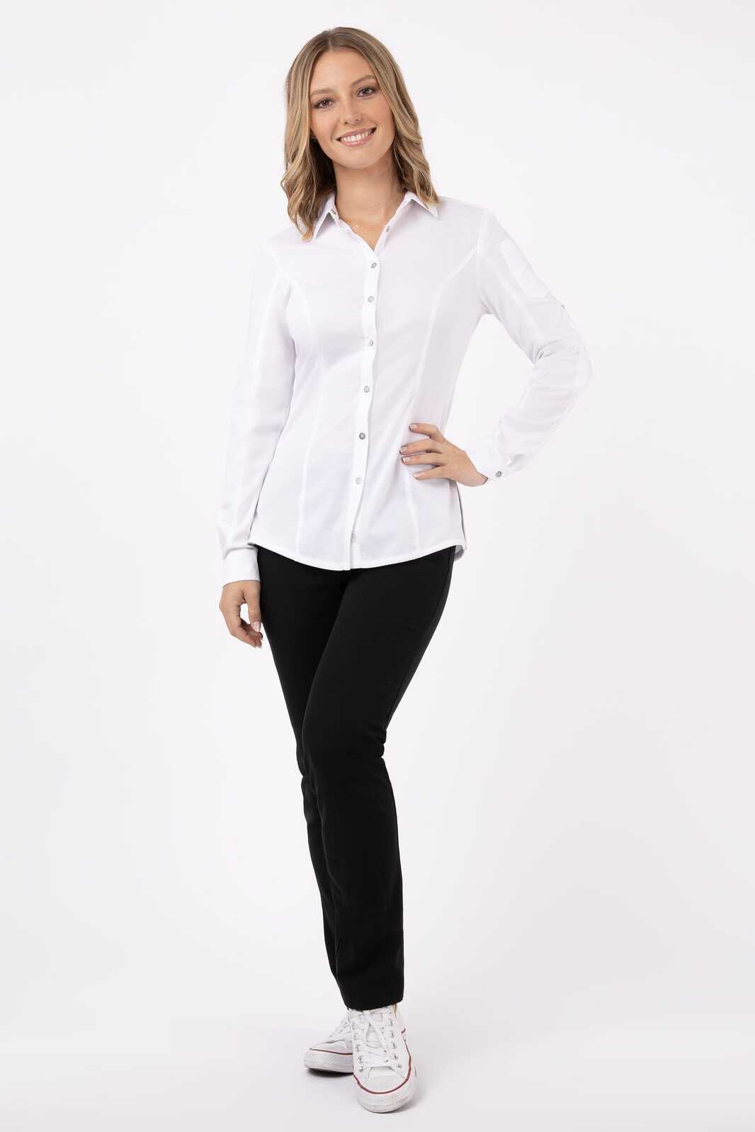 A woman wearing a white button-up shirt paired with black trousers and sneakers, standing in a relaxed pose.