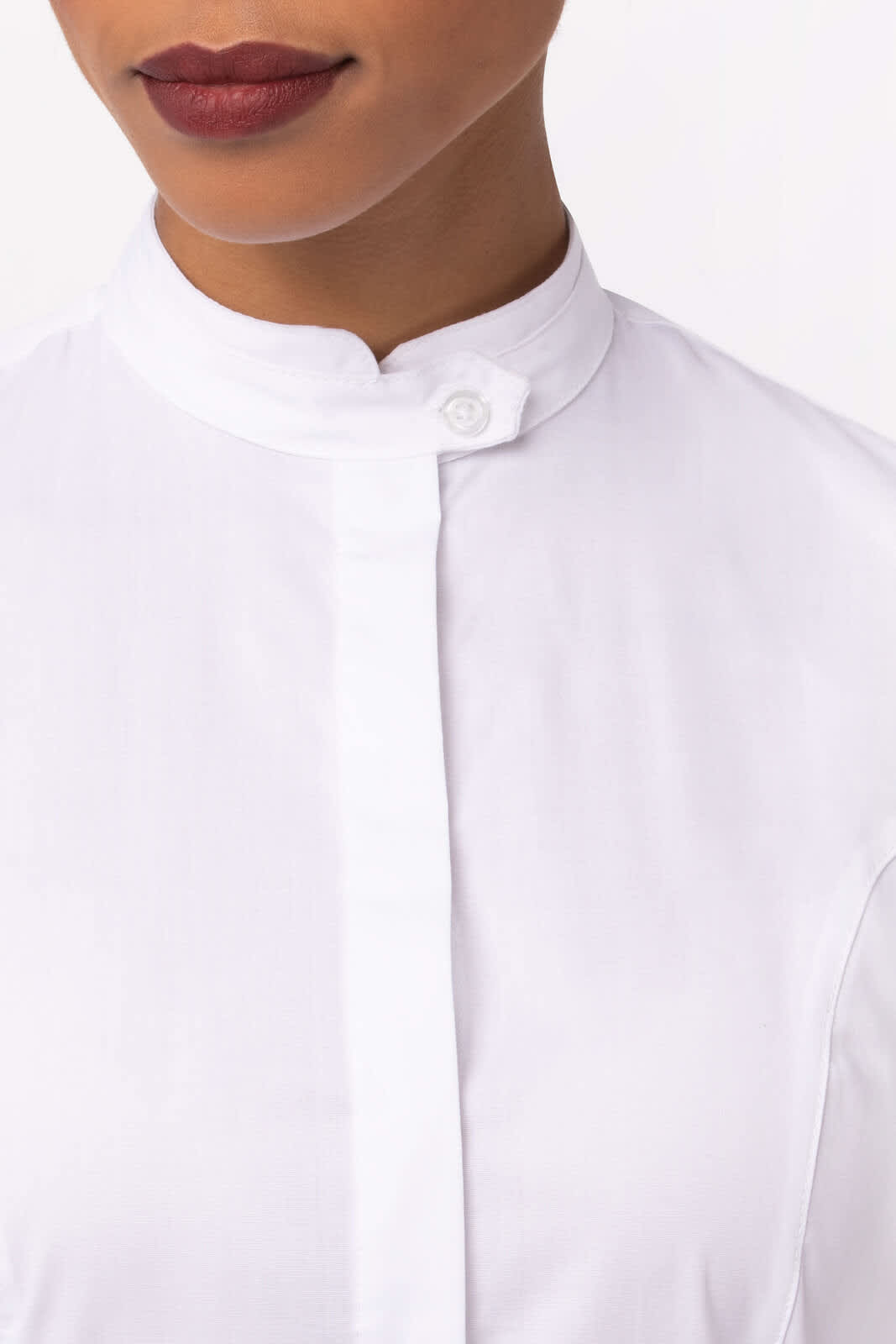 A white button-up women's shirt with a high collar and a small logo on the side.
