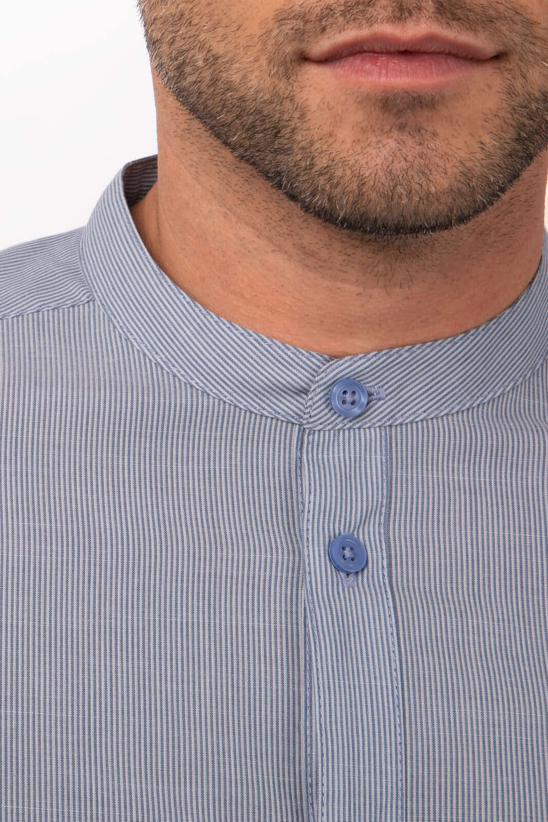 A close-up of a blue and white striped button-up shirt with a standing collar, featuring two buttons.