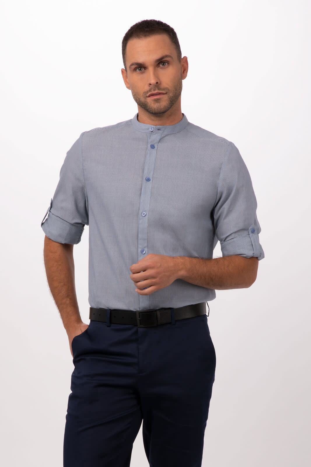 A button-up shirt in light blue with rolled sleeves, worn with dark navy trousers and featuring a logo.