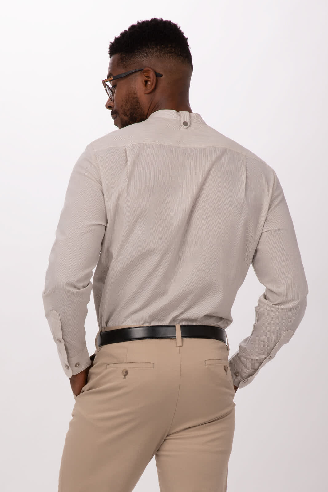 A light beige button-up shirt with long sleeves, featuring a collar and a branded logo.