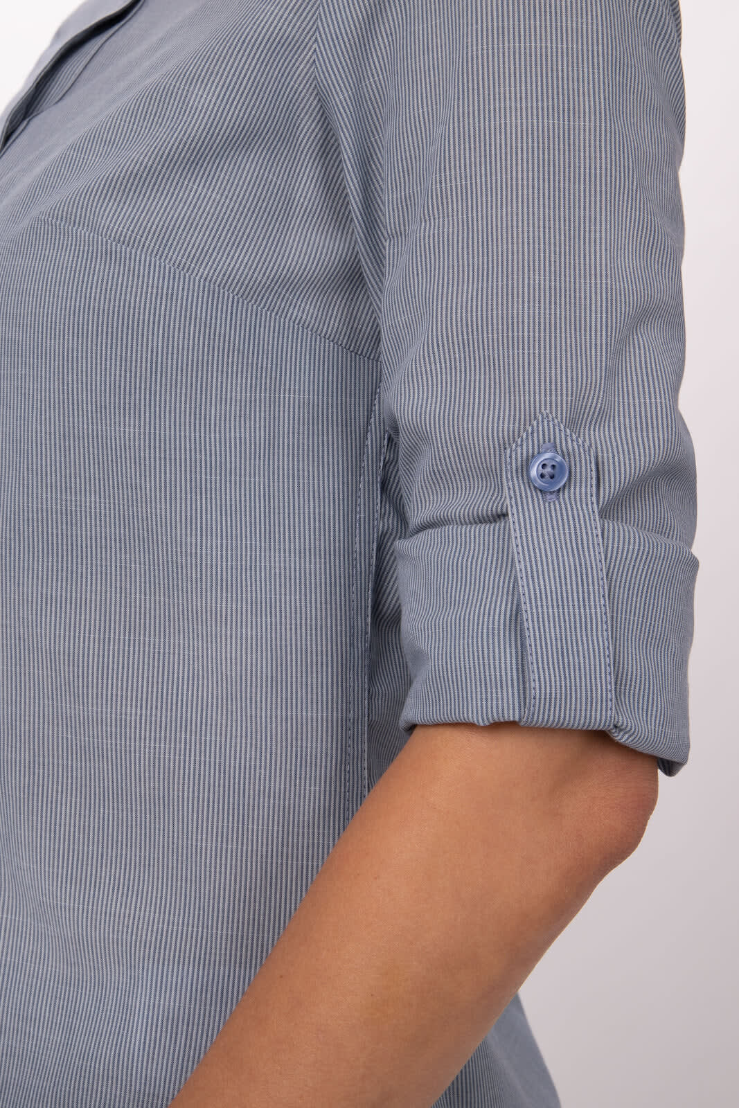 A blue and white striped women's button-up shirt with rolled-up sleeves and a button detail on the cuffs.