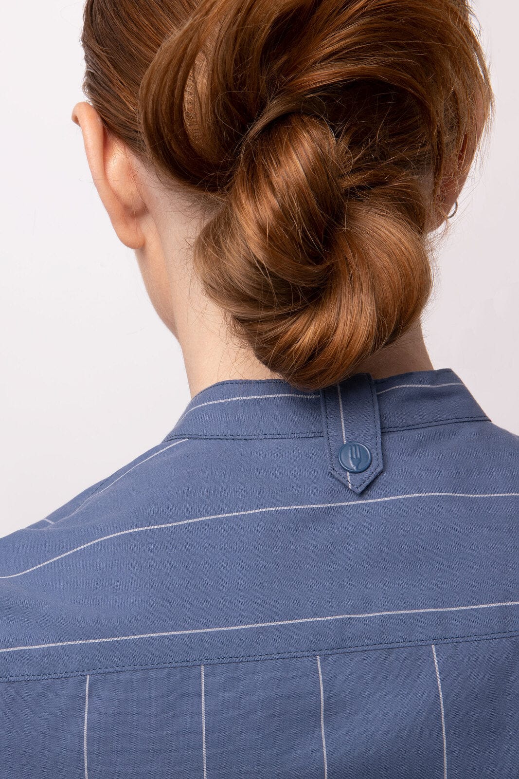 A back view of a blue women's shirt featuring vertical stripes and a button at the collar.