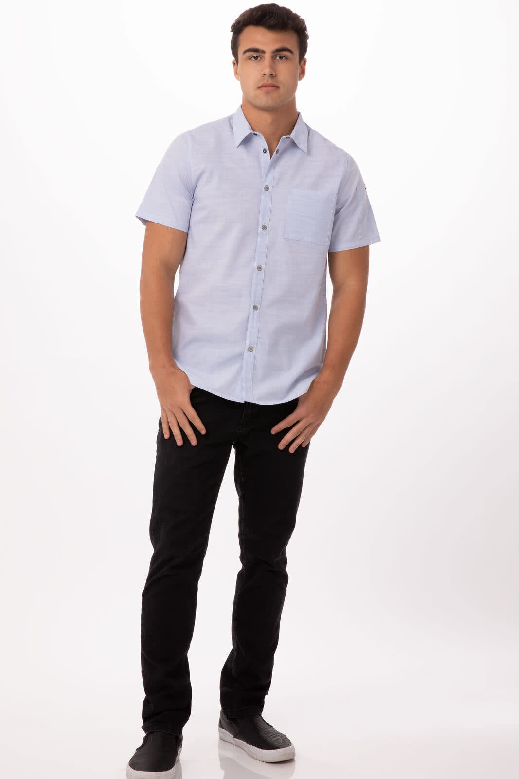 A short-sleeved, light blue men's shirt with buttons, paired with black trousers and shoes. The shirt features a logo.