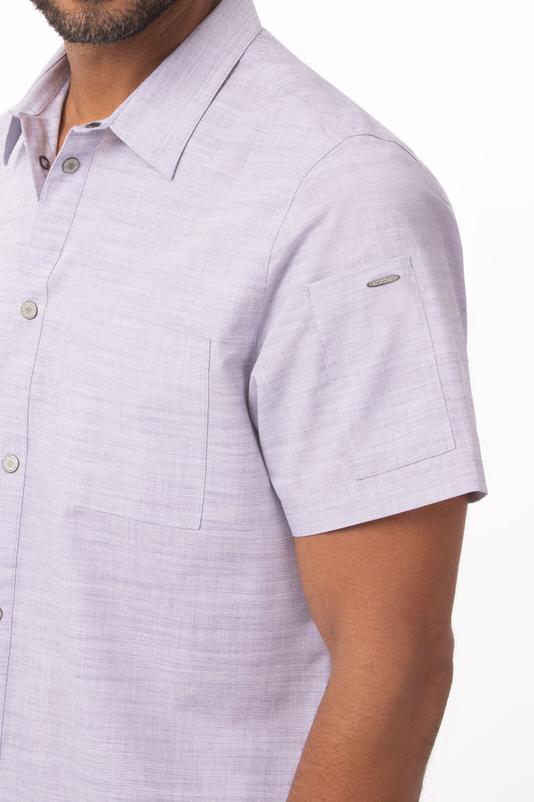 A short-sleeved men's shirt in light purple with a pocket and a logo on the sleeve.