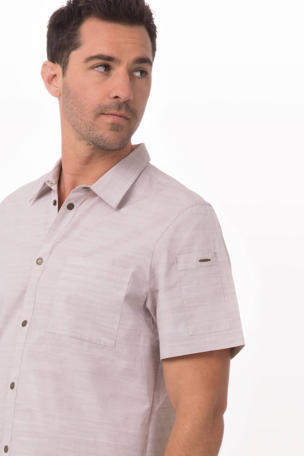 A short-sleeved men's shirt in a light neutral colour with two front pockets and a logo on the sleeve.
