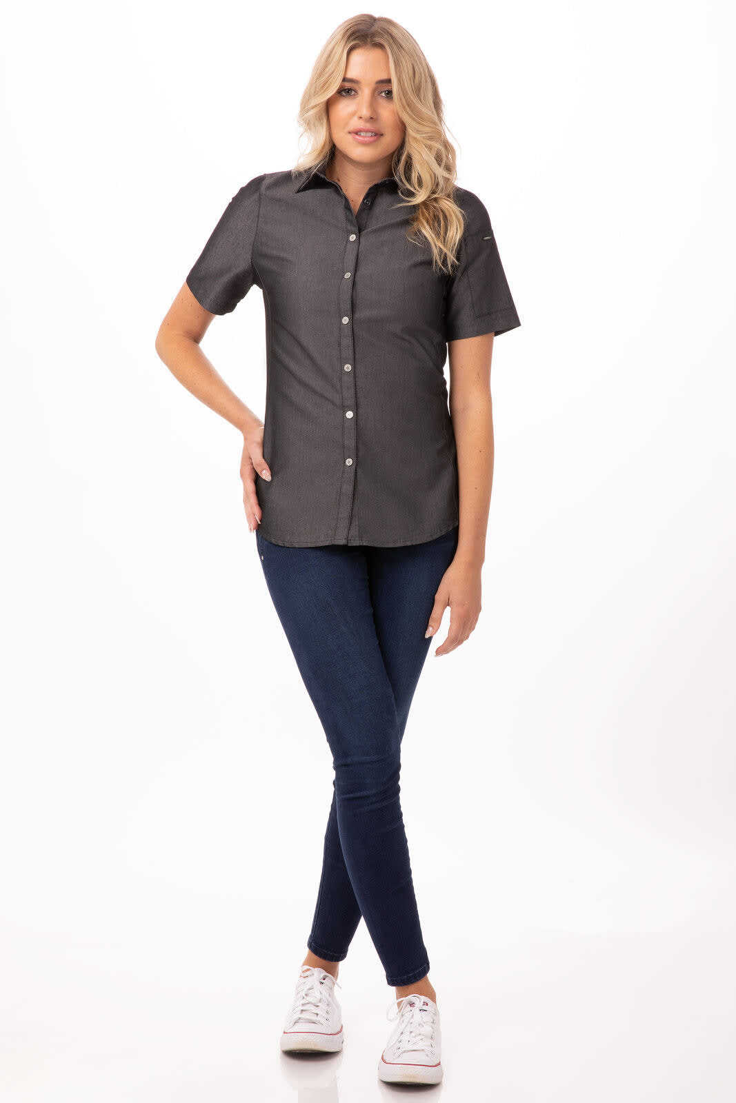 A grey women's denim shirt with a button-down front, paired with blue jeans and white sneakers, featuring a logo.