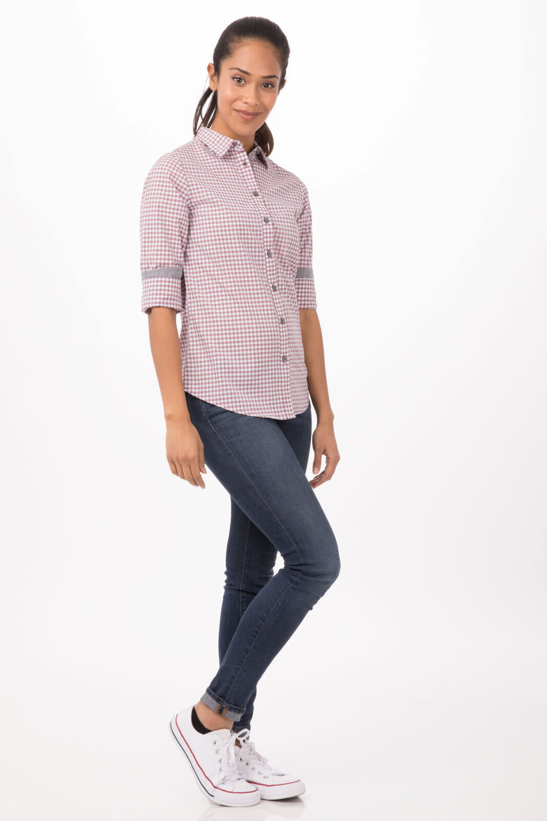 A woman wearing a long sleeve, modern gingham button-up shirt in red and white, paired with jeans and sneakers.