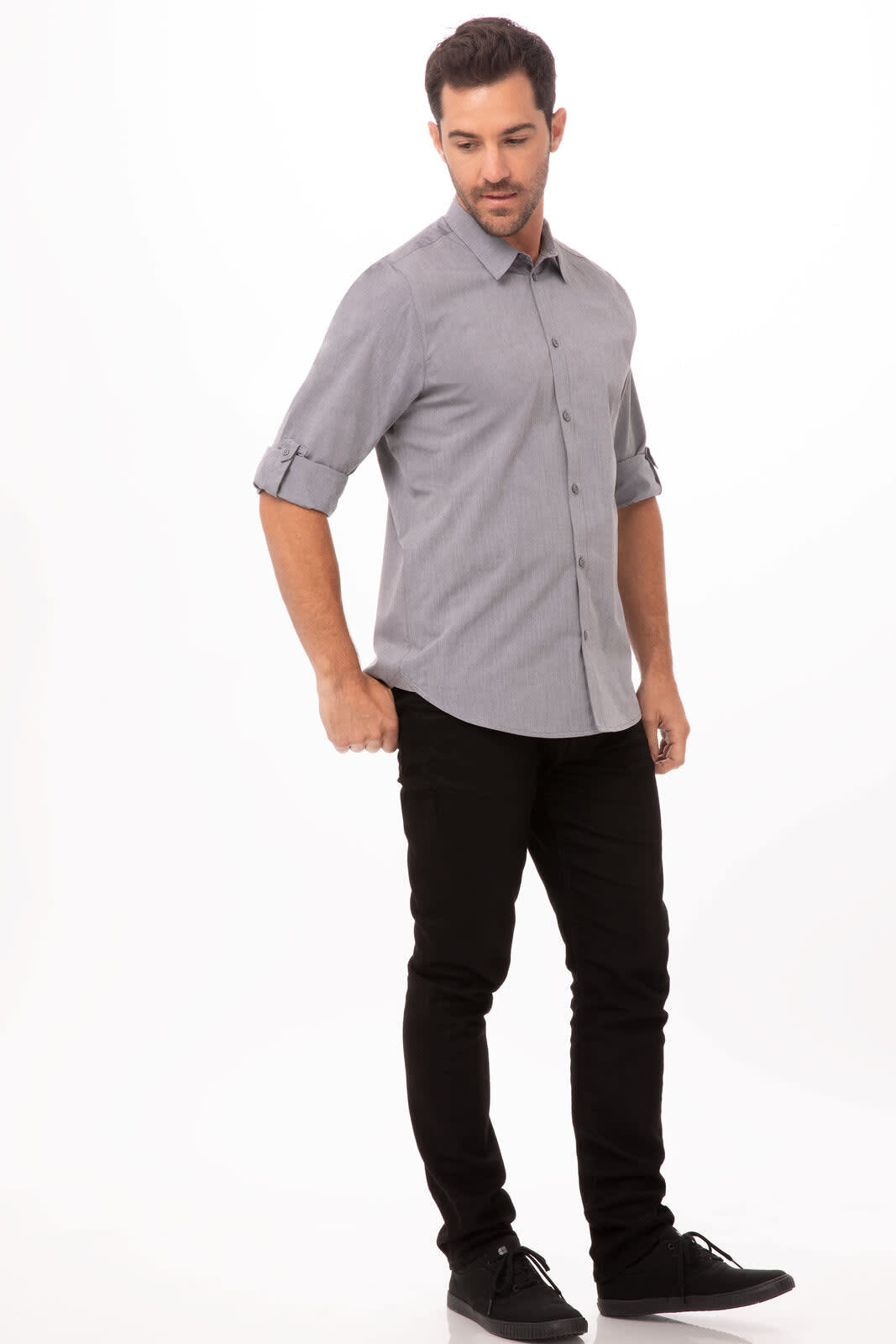 A grey chambray men's dress shirt with rolled sleeves, paired with black trousers and casual shoes.
