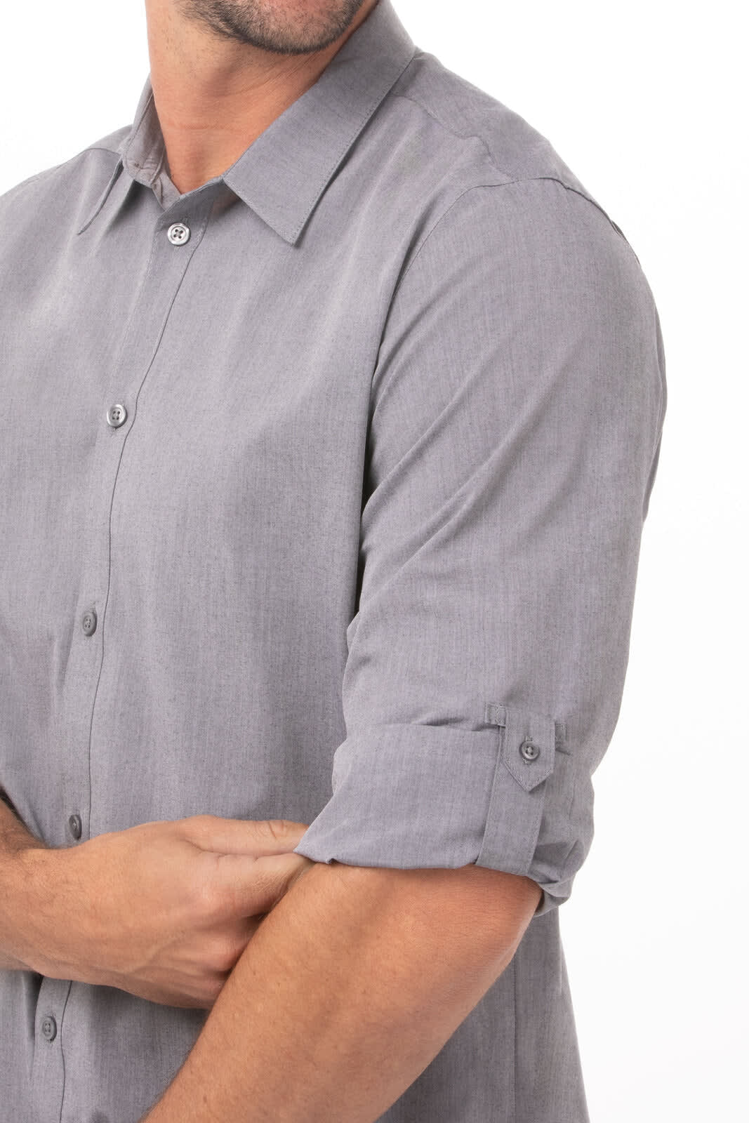 A modern chambray men's dress shirt in grey, featuring button-up details and rolled sleeves. It has a logo on the fabric.